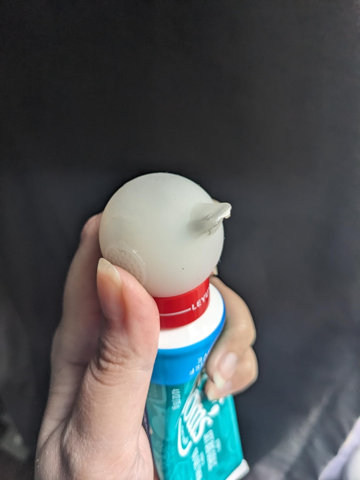 Hand holding a bottle of mouthwash using the White Snow buddie