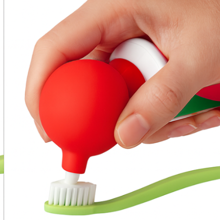 Hand using a red and white device to apply toothpaste onto a green toothbrush, with text indicating 'Buddies' brand and product features.